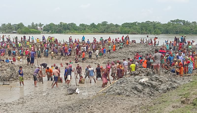 খুলনার পাইকগাছার কালীনগর গ্রামের ভেঙে যাওয়া বাঁধ স্বেচ্ছাশ্রমে মেরামত করছেন মানুষ